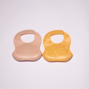 2 Mushie silicone baby bibs | blush and sun orange